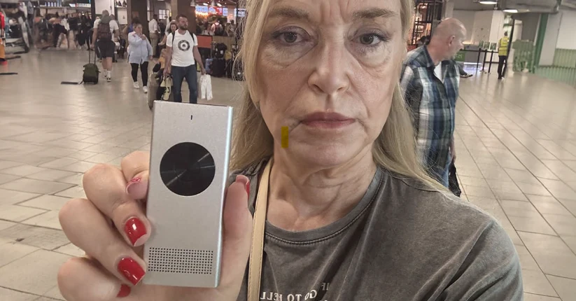 Traveler holding the Enence handheld translator in an airport
